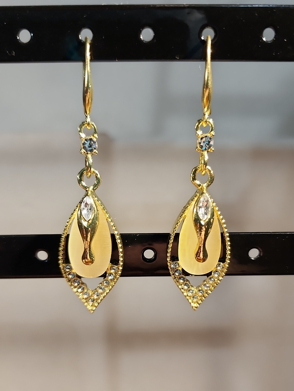 Elegant Yellow-Golden Synthetic Teardrop Earrings With sparkling White Cat Eye